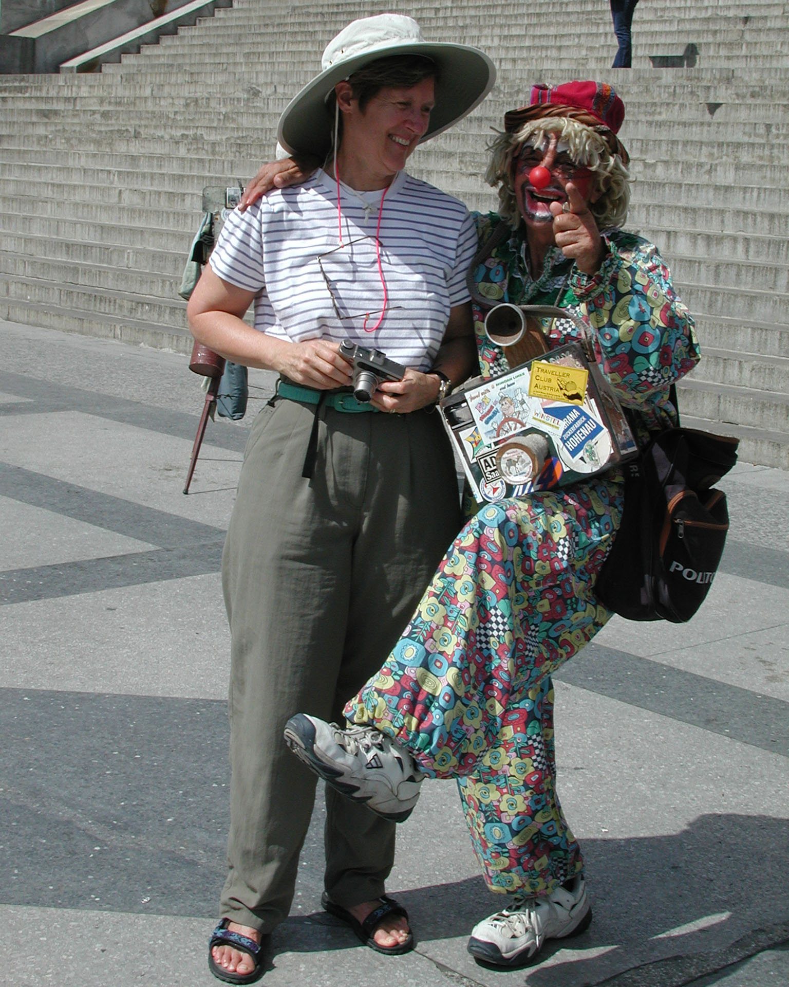 Fiona with a clown in front of the government building 2 frames back.