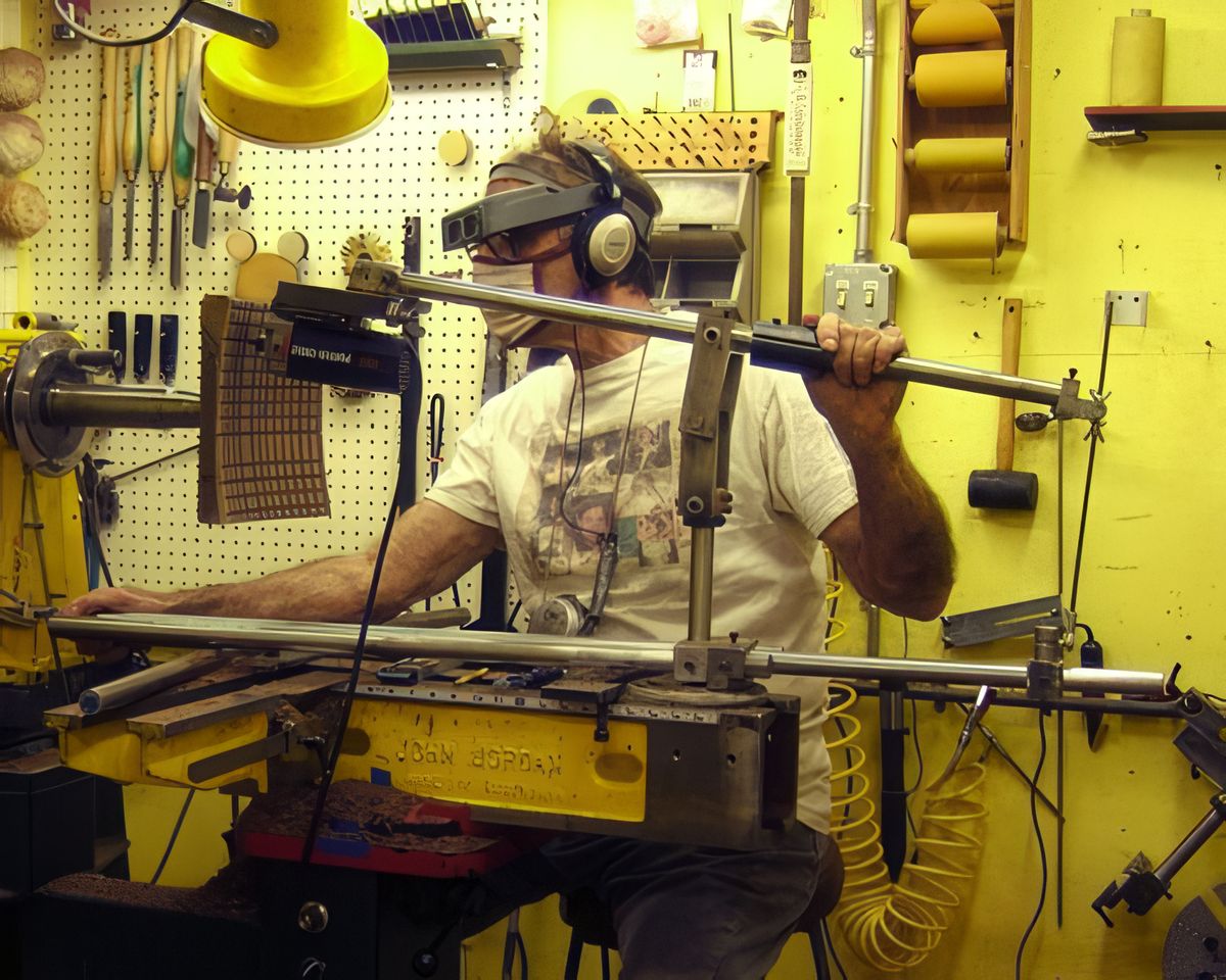 Harvey at the lathe. Headphones to quiet the router, magnifiers to see details and sitting because I get better control.