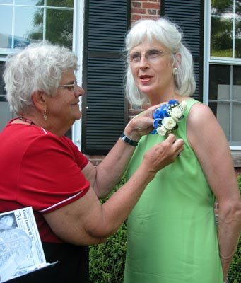 Nancy Miller pins a corsage of the school colors on Cherry before the induction ceremony at PDS.